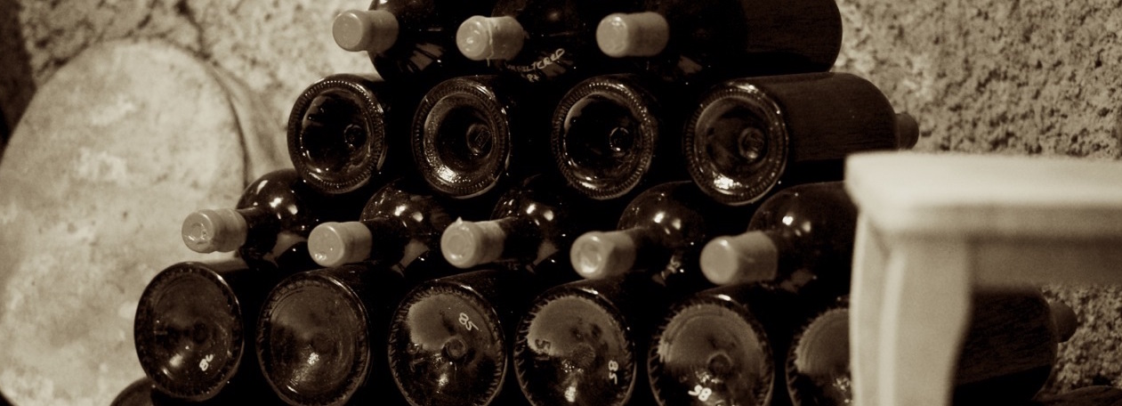 Stacked bottles by a cellar wall